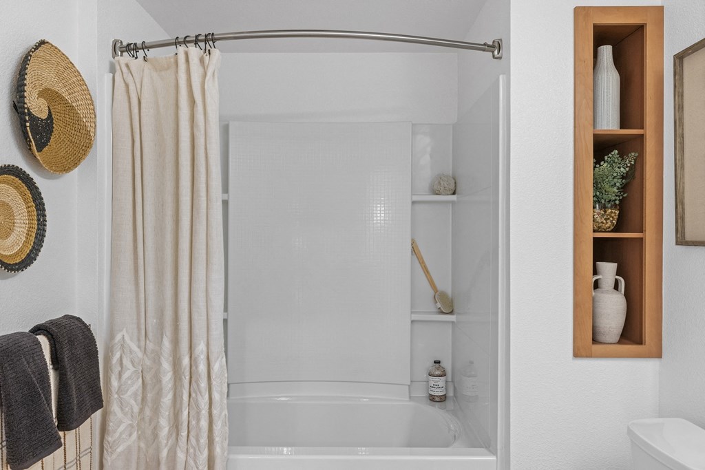 The Edge Milpitas CA a bathroom with a white bathtub and a white shower curtain