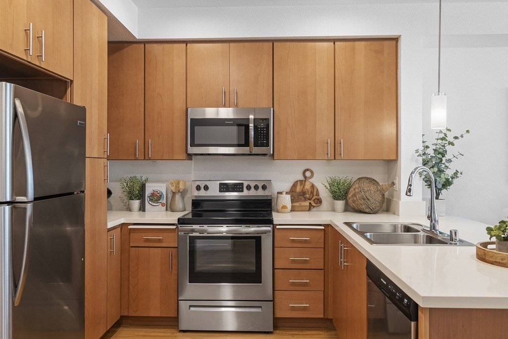 The Edge Milpitas CA a kitchen with wooden cabinets and stainless steel appliances