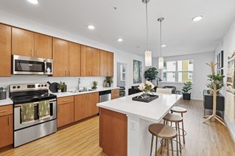 The Edge Milpitas CA a kitchen with white countertops and wooden cabinets