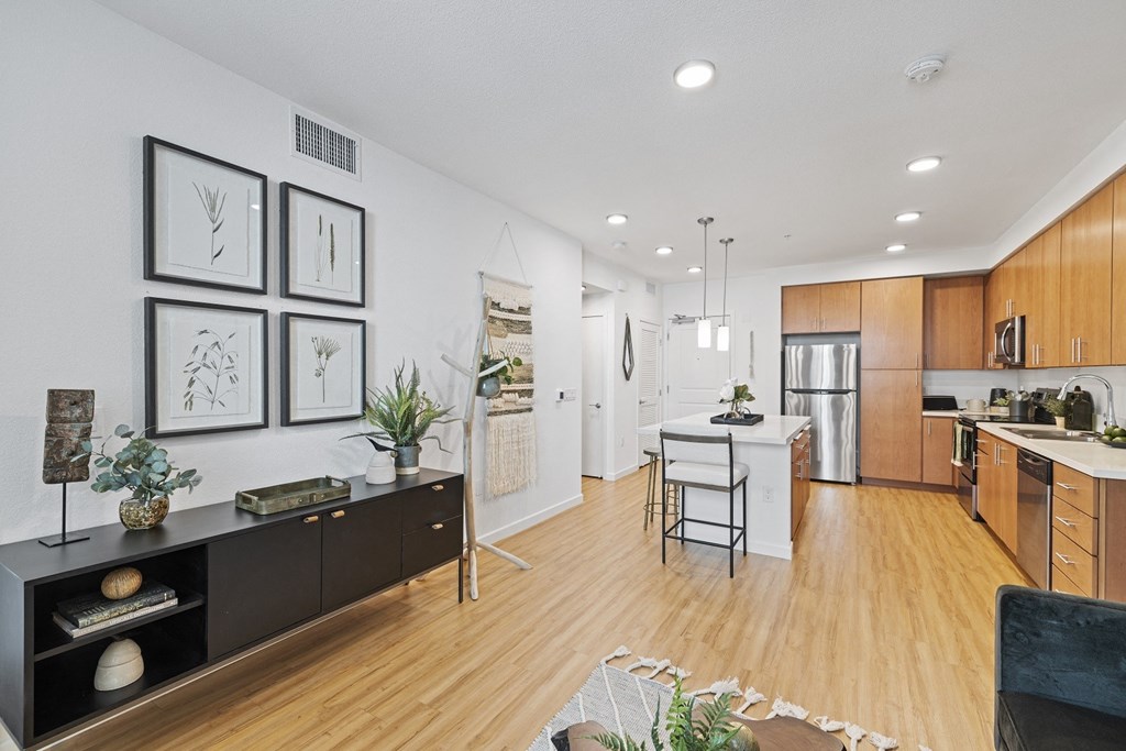 The Edge Milpitas CA a kitchen and living room with hardwood floors and white walls
