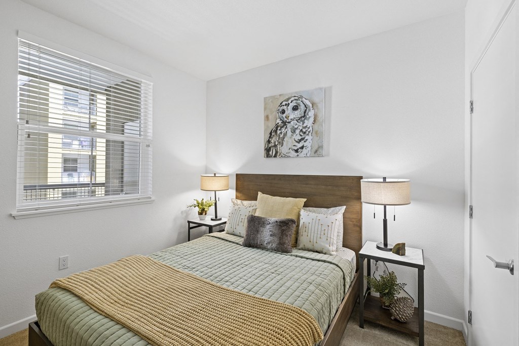 The Edge Milpitas CA a bedroom with a bed and two night stands with lamps