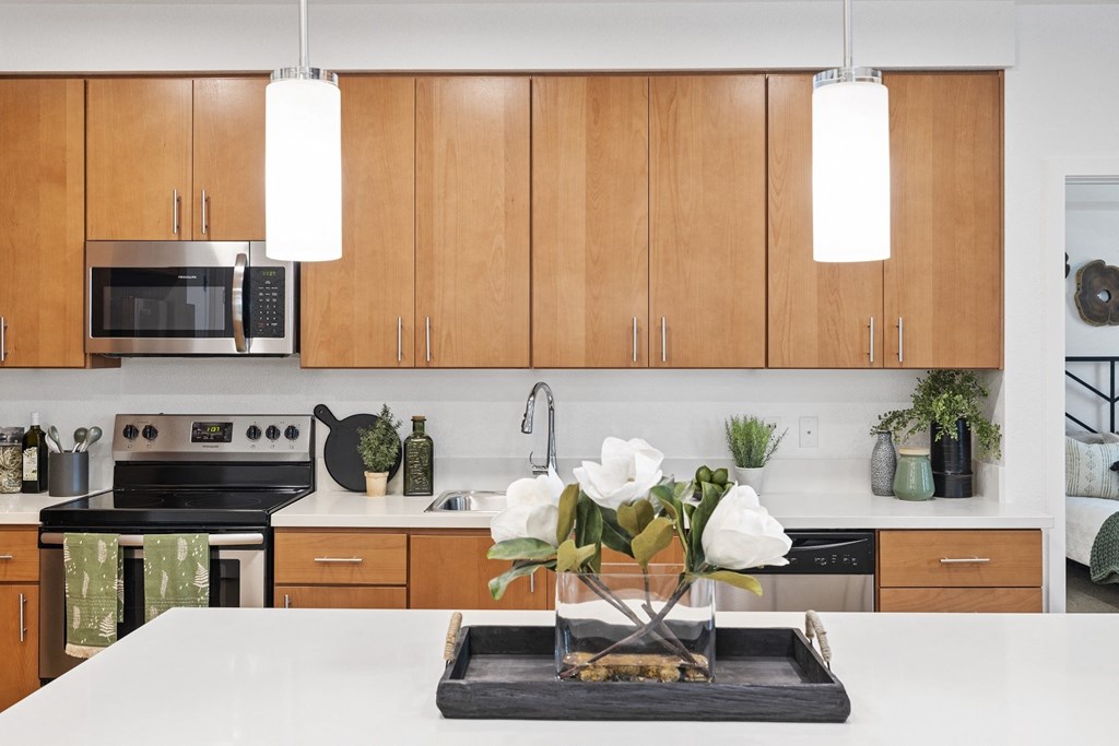 The Edge Milpitas CA a kitchen with white countertops and wooden cabinets