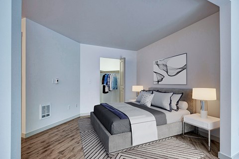 A bedroom with a bed, nightstand, and lamp.