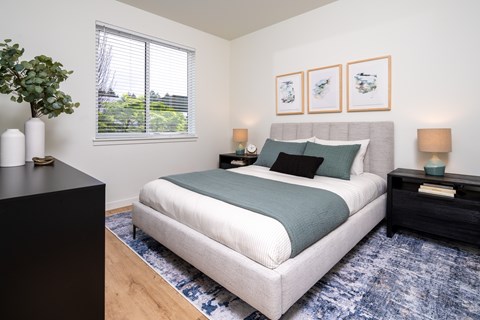 A bedroom with a large bed and a black dresser.