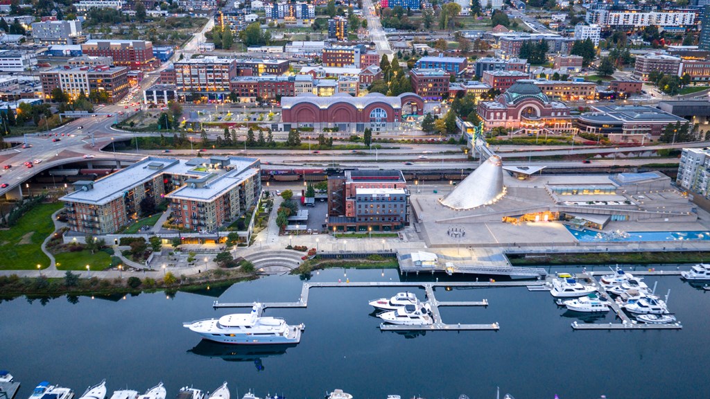 A cityscape with a marina and boats docked in the foreground.