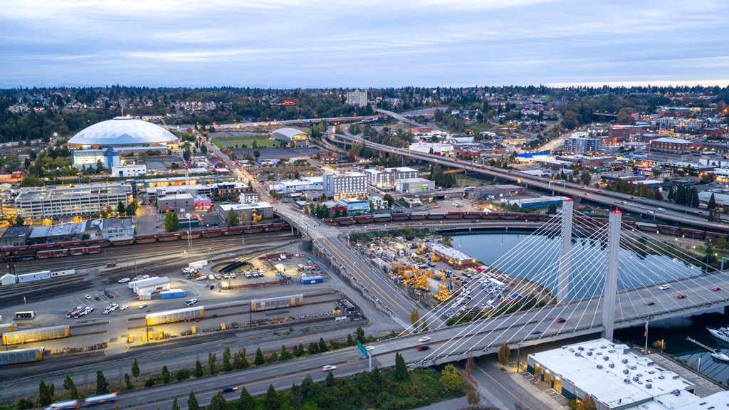 A busy city intersection with a large white dome structure in the background.