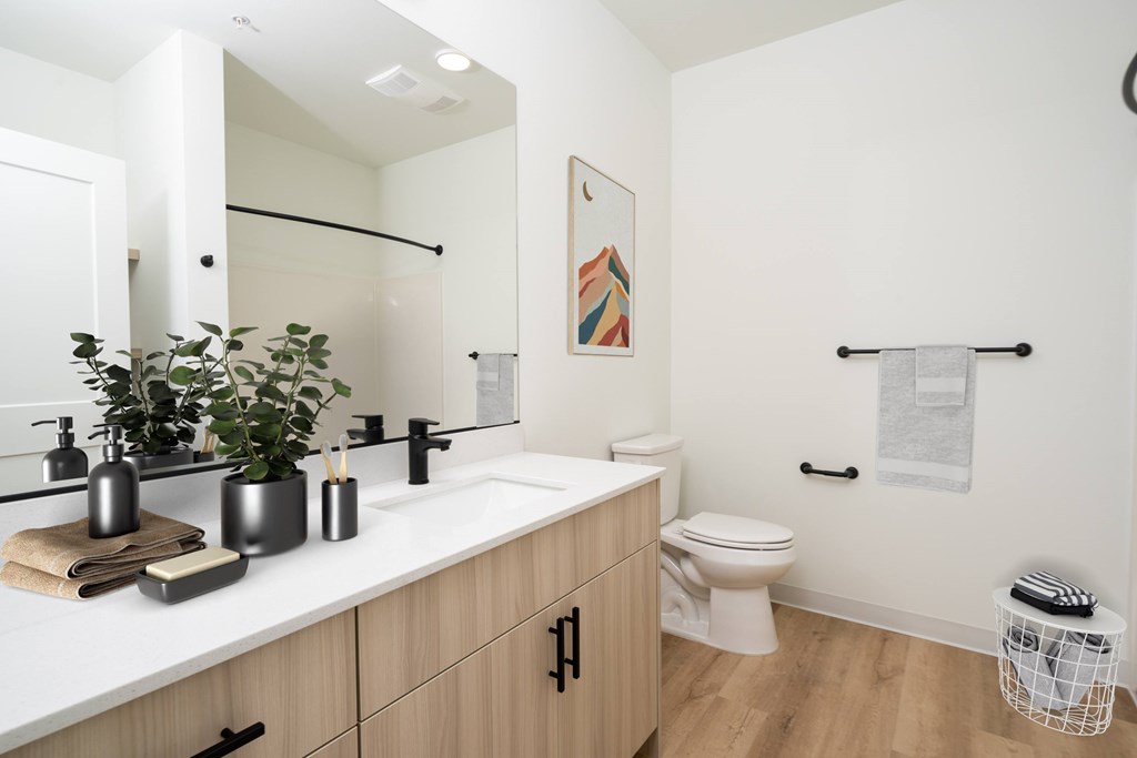A bathroom with a white counter top and a white toilet.