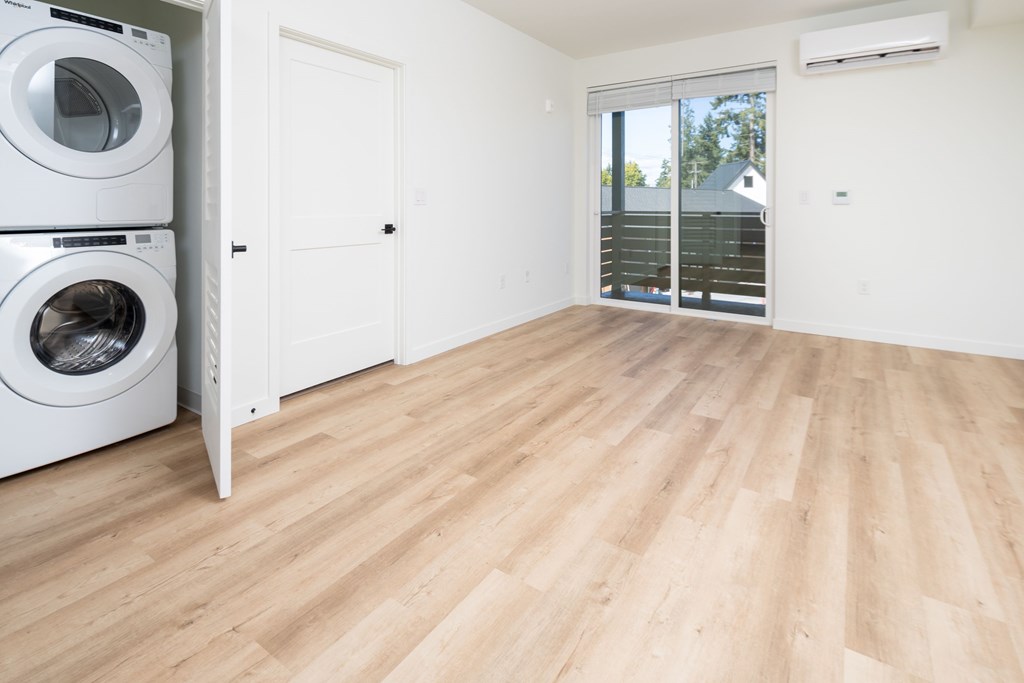 A room with a washer and dryer stacked on top of each other.