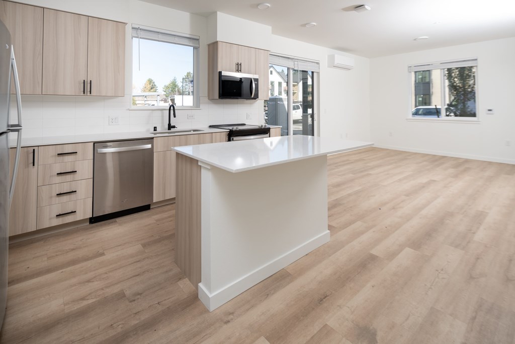 A kitchen with wooden floors and a white island.