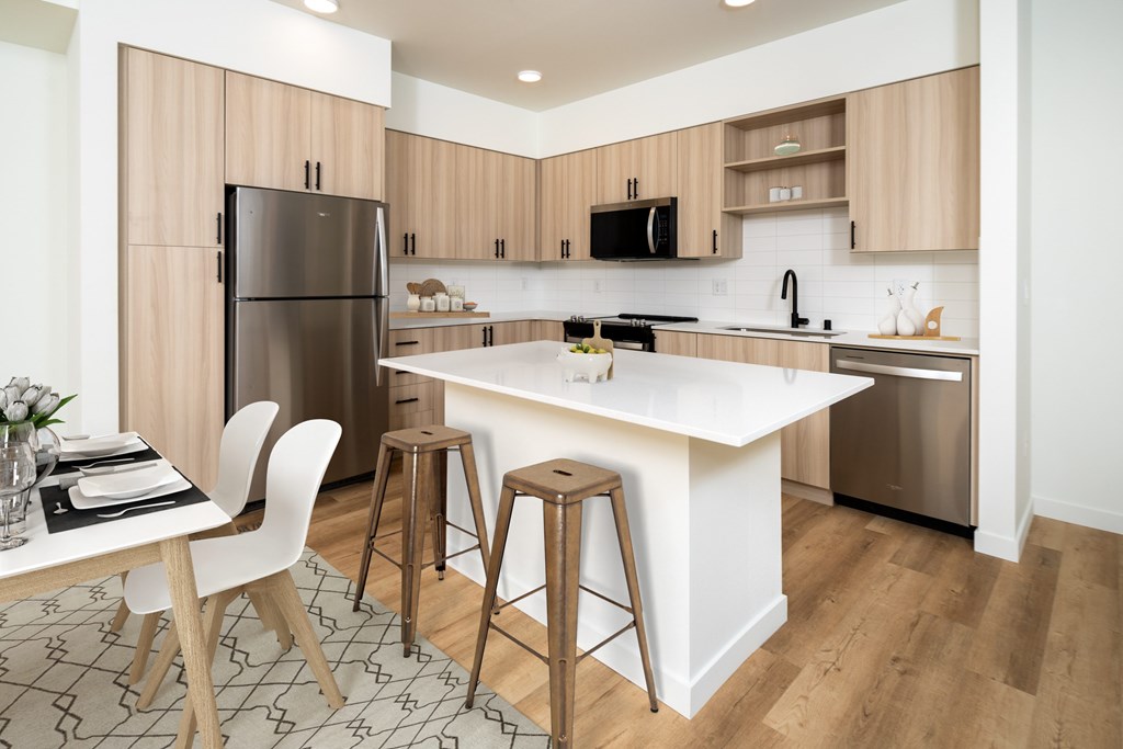A kitchen with a white countertop and wooden cabinets.