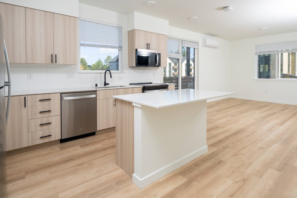 A kitchen with wooden cabinets and a white island.
