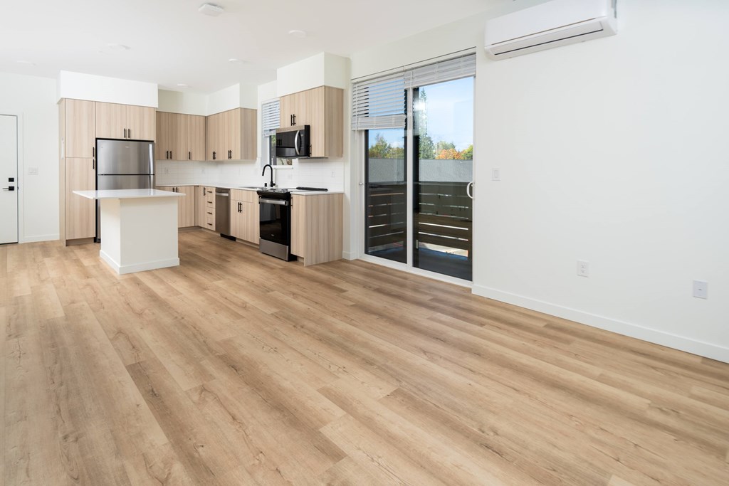 A kitchen with wooden floors and a white island.