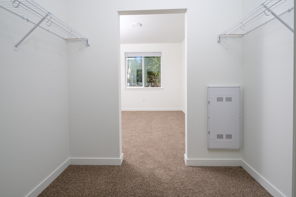 A white room with a window and a white cabinet.