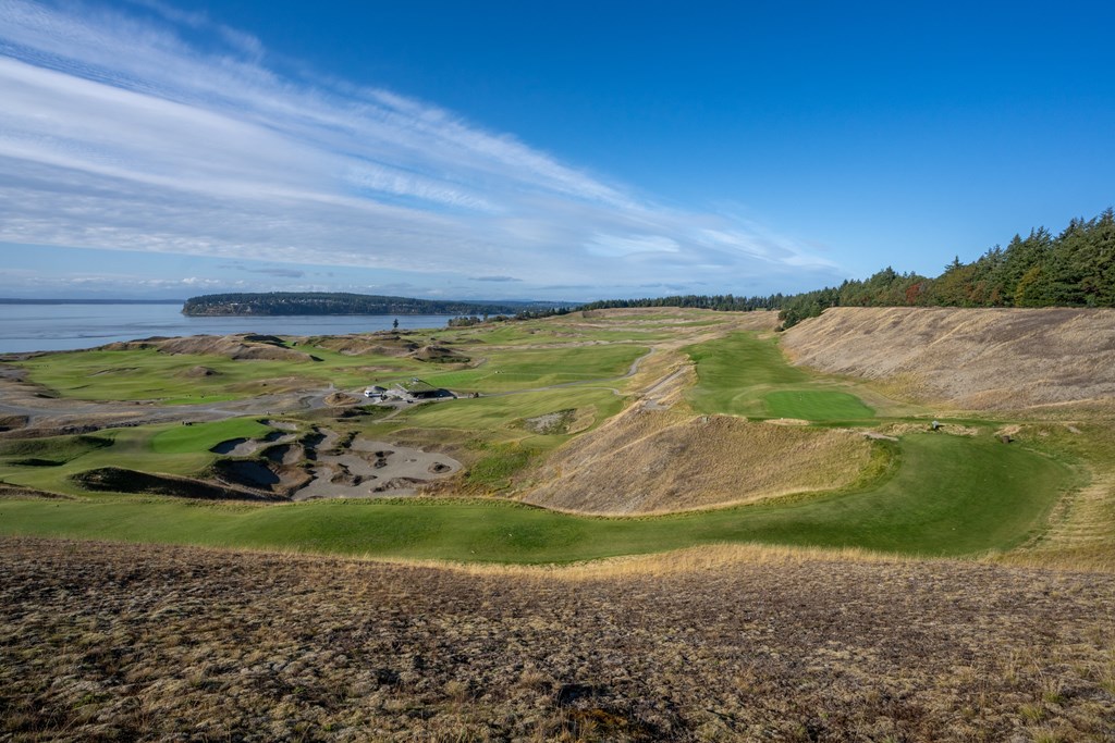 A golf course with a green and a small island in the distance.
