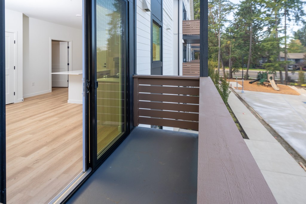 A modern house with a glass door and a wooden deck.