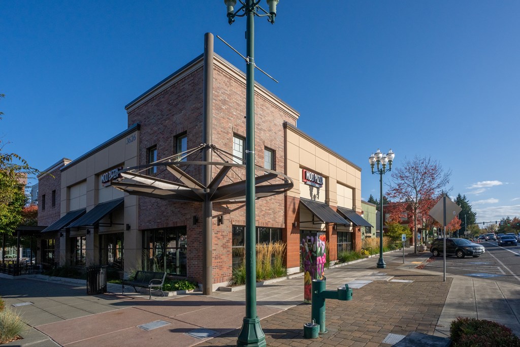 A street view of a building with a green pole in front.