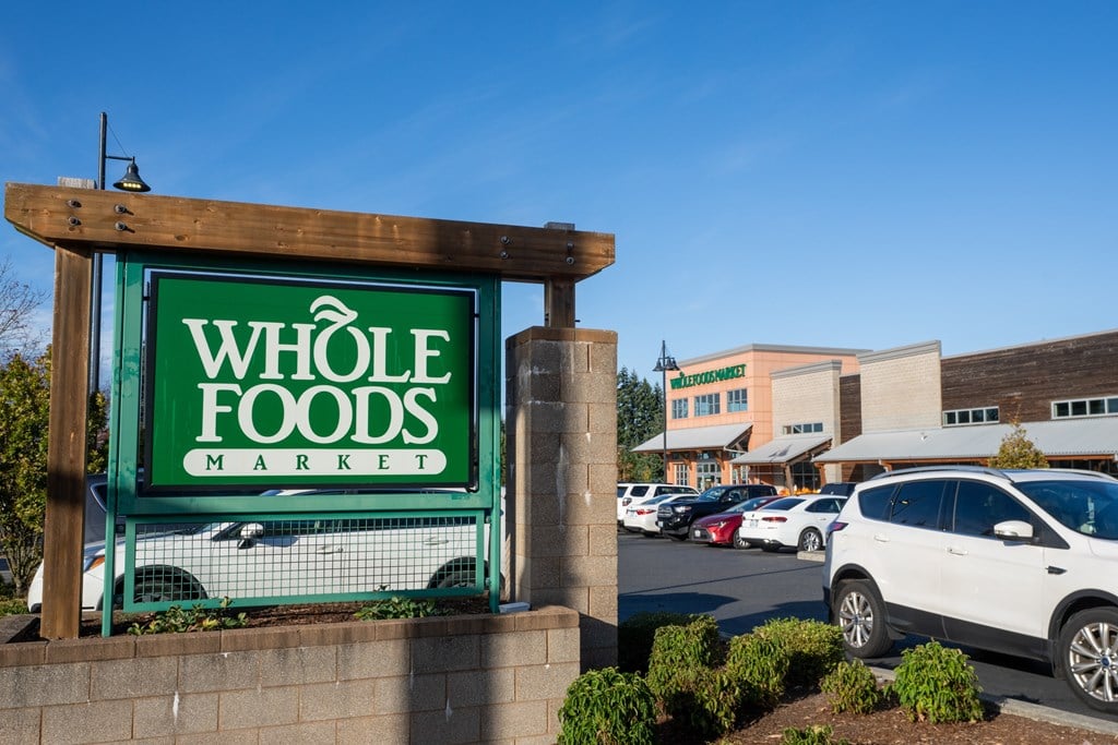 A Whole Foods Market sign is displayed in front of a parking lot.