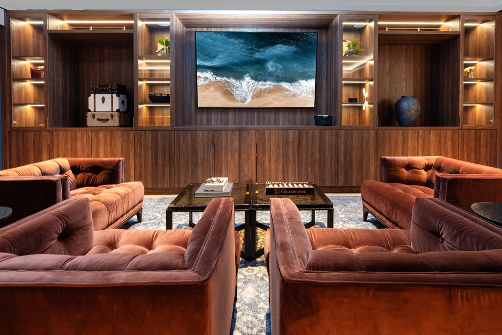 A living room with a large screen TV and a coffee table in the middle.