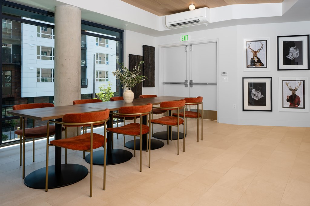 A room with a table and chairs and pictures on the wall.