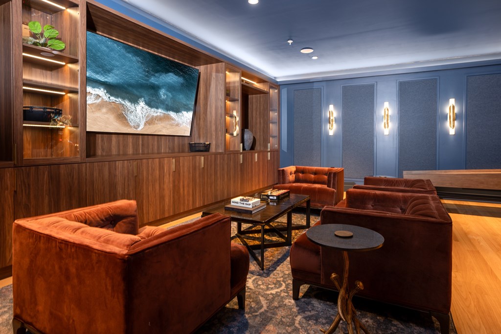 A living room with a large screen and a brown sofa.