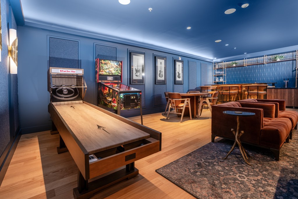 A room with a shuffleboard table and a pool table.