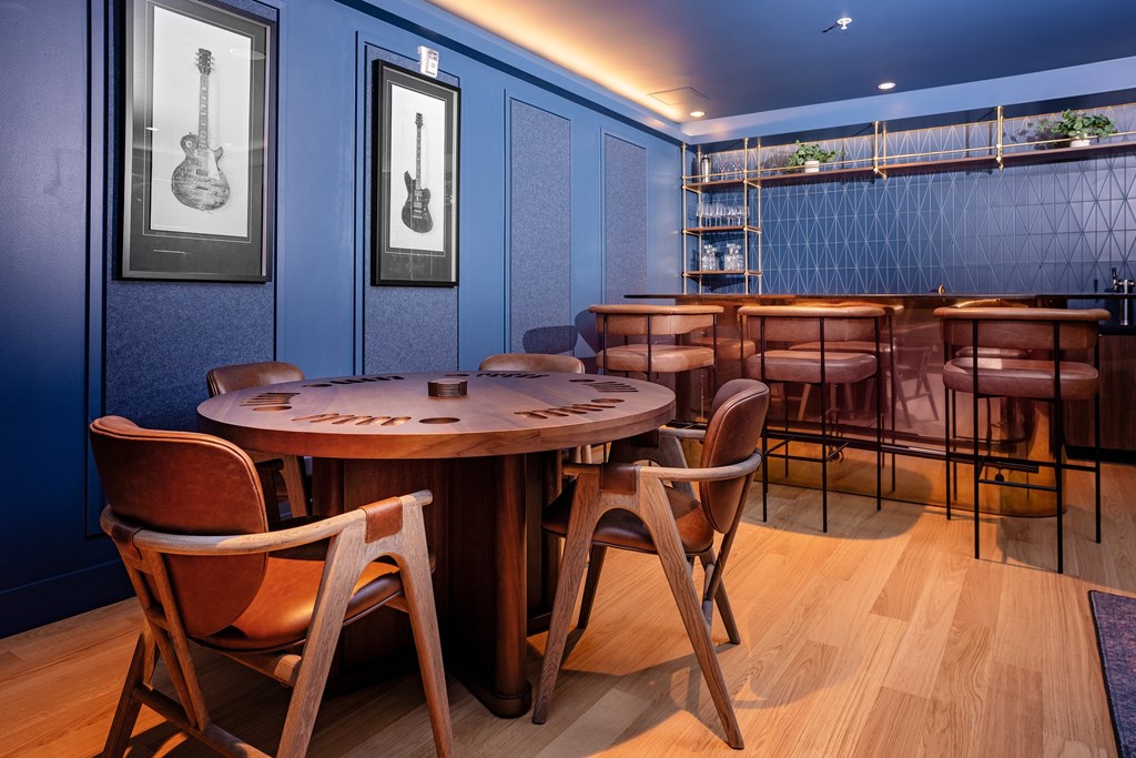 A round wooden table with chairs around it in a room.