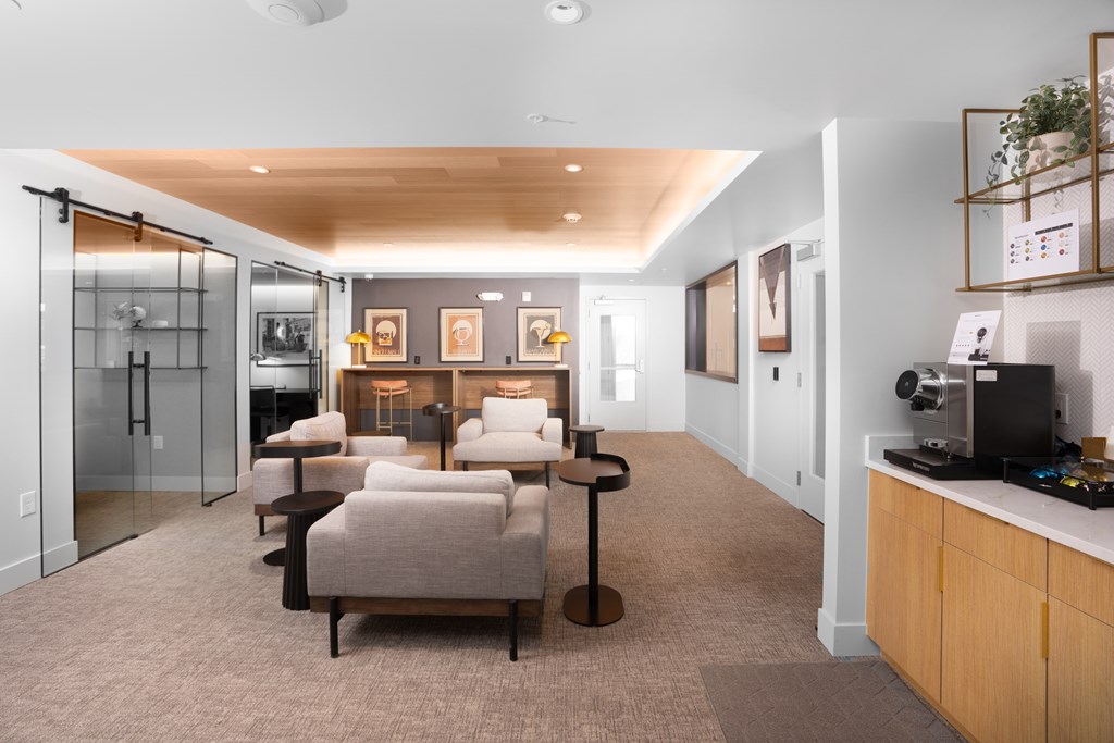 A modern living room with a kitchen area in the background.