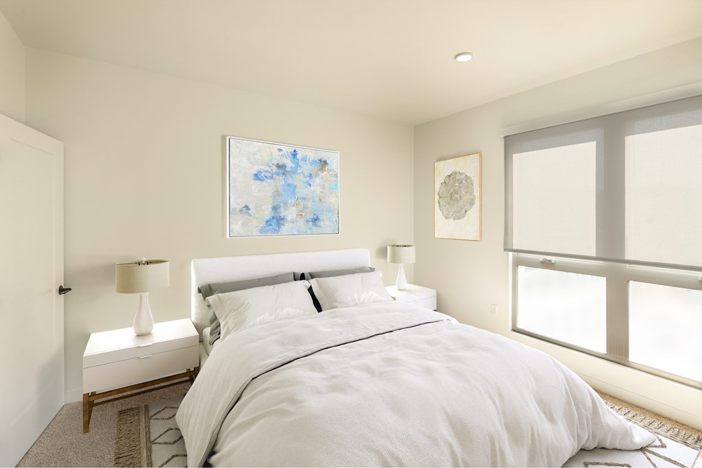 A bedroom with a large bed, a nightstand with a lamp, and a painting on the wall.