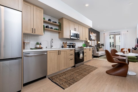 A modern kitchen with wooden cabinets and a refrigerator.