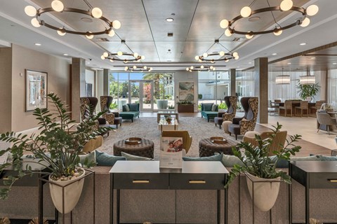 A spacious waiting area with multiple seating options and potted plants.