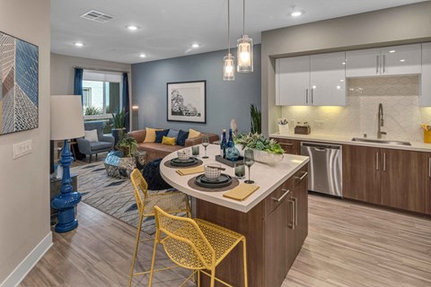 A modern kitchen with a dining table set for two.
