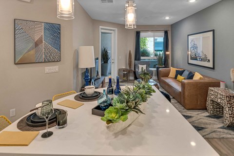 A modern dining room with a white table set for two.