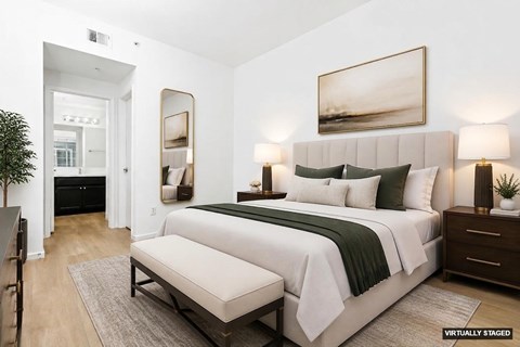 A bedroom with a large bed and a painting on the wall.