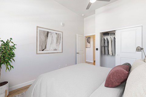 A bedroom with a large bed and a plant.
