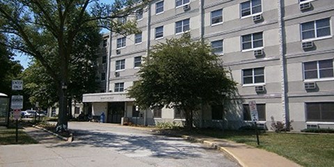 an apartment building with a tree in front of it