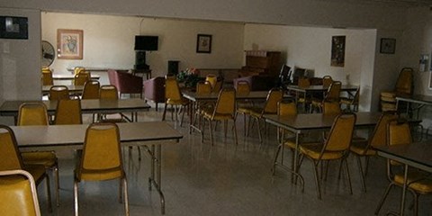 a dining room with tables and chairs and a piano