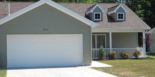 a white garage door in front of a house