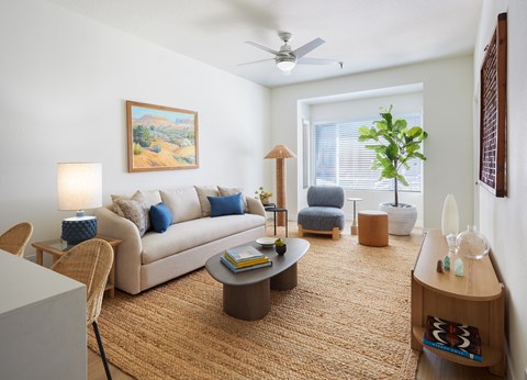 A living room with a couch, chair, and a painting on the wall.