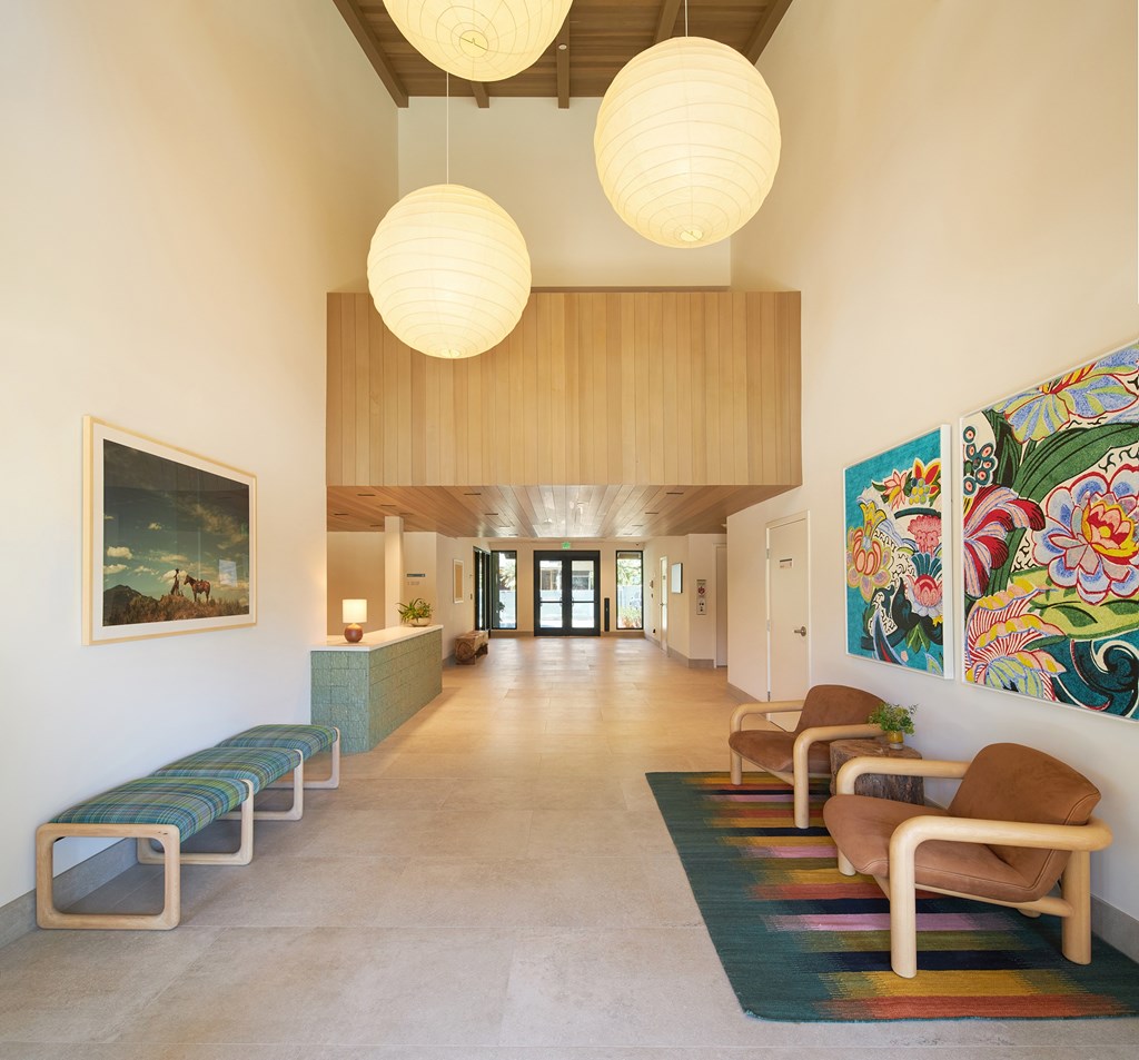 A hallway with a bench and a painting on the wall.