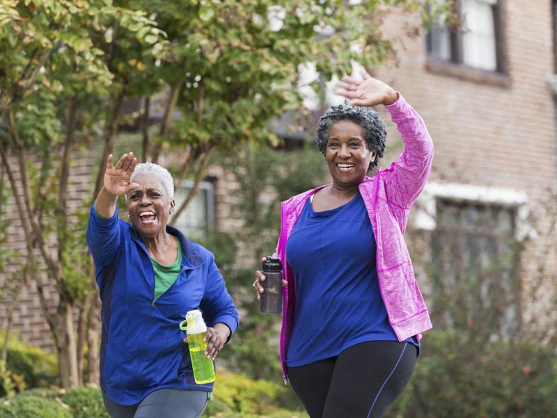 two women walking in a yard with their hands in the air