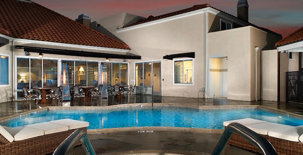 a swimming pool in front of a house with a pool
