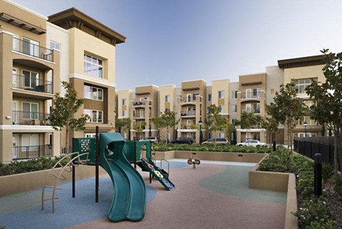 a childrens playground in the middle of an apartment complex
