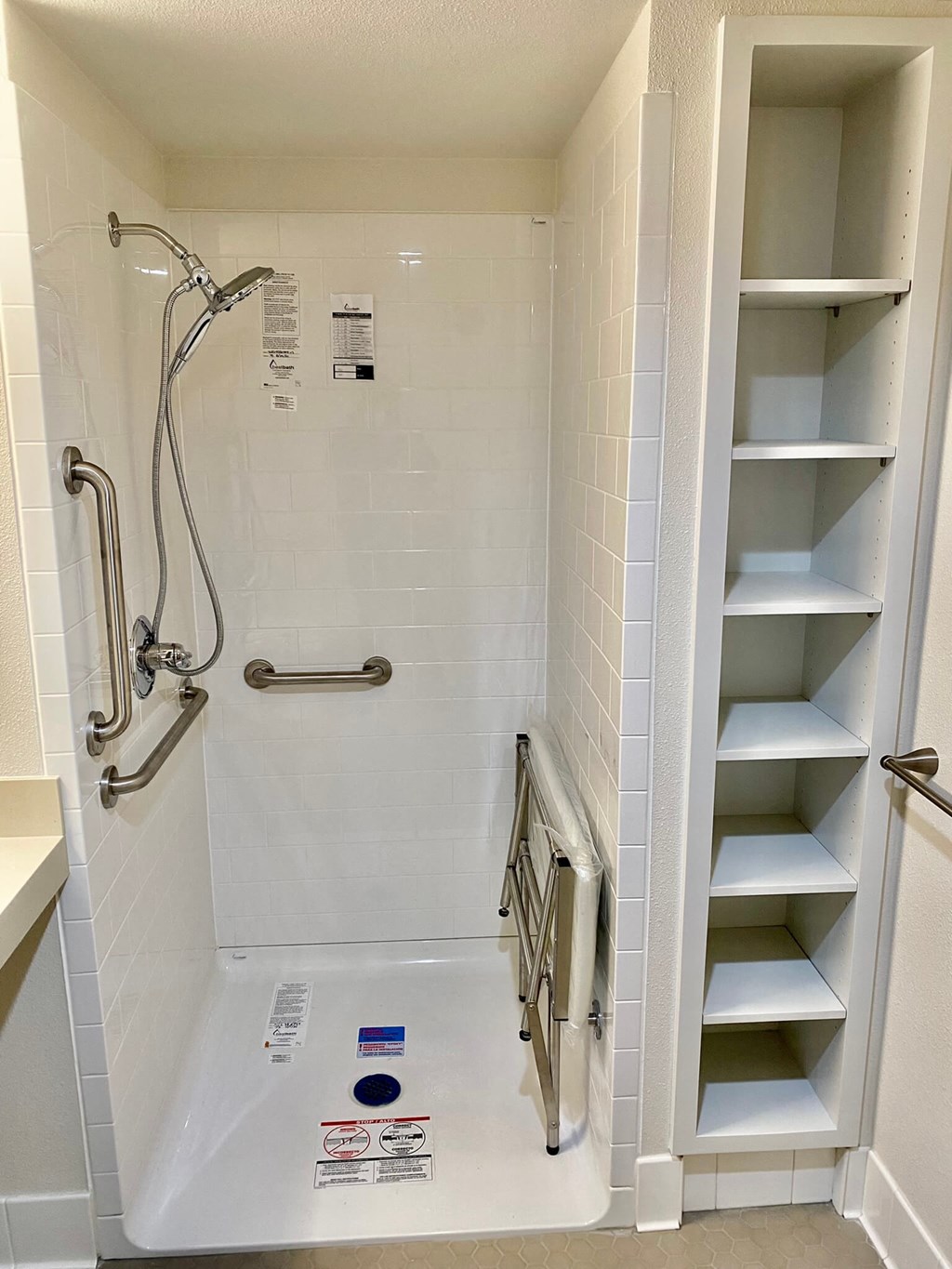 a walk in shower with shelving in a bathroom