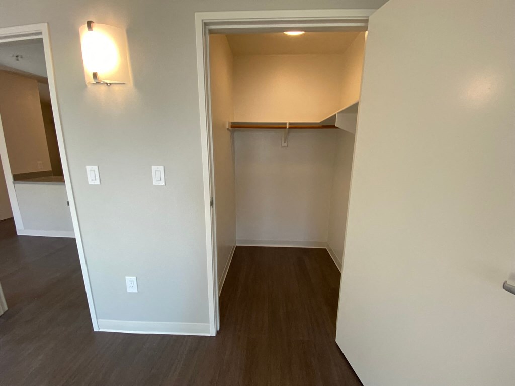 an empty living room with wood floors and a closet