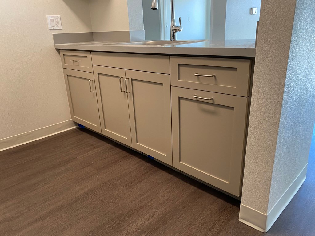 a vanity with white cabinets and a sink in a bathroom
