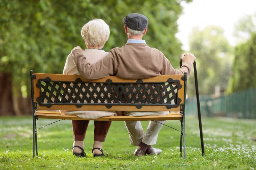 a man and a woman sitting on a park bench