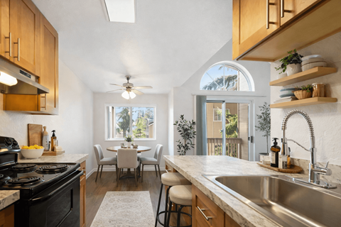 A kitchen with a black stove top oven and a white counter top.