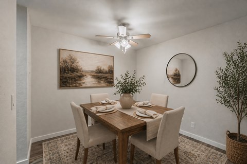 A dining room with a table set for four and a painting on the wall.
