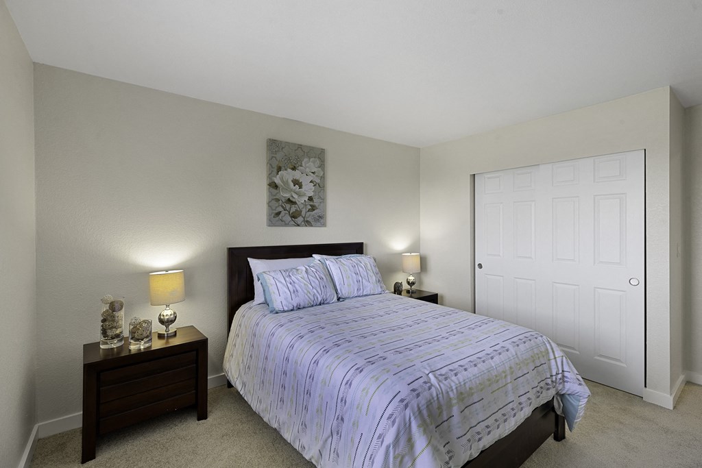 a bedroom with a bed and two night stands at Campo Basso Apartment Homes, Washington, 98087