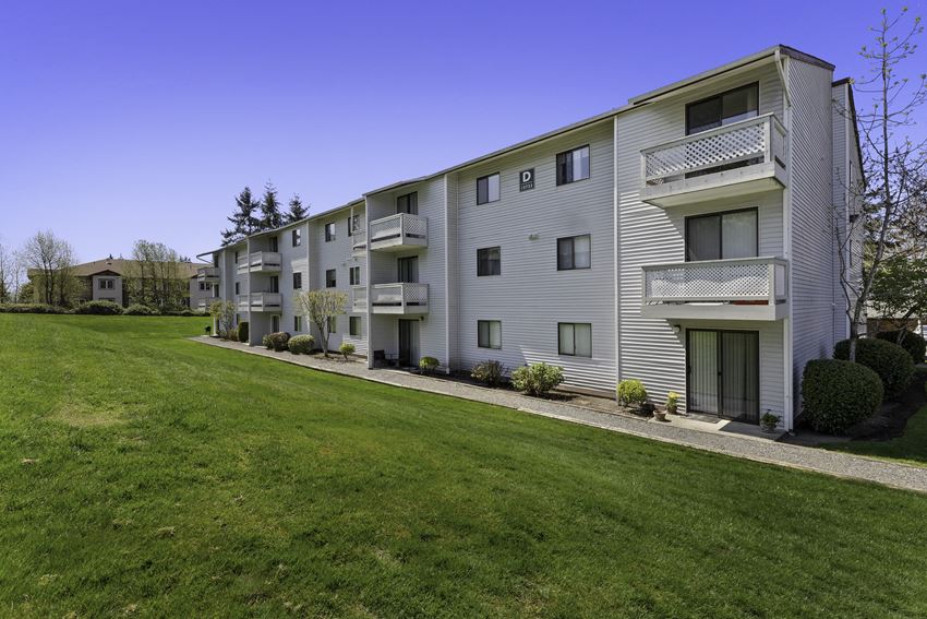 Property View of Apartment Building with Grassy Backyard Area and Wide Open Natural Space Property View of Apartment Building with Grassy Backyard Area and Wide Open Natural Space at Campo Basso Apartment Homes, Washington
